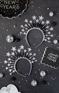 Black Happy New Year napkin styled on a New Year’s Eve table with star headbands and disco balls