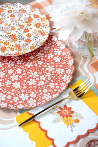 Harvest place setting with ditsy floral plates, a fall bouquet napkin, gold fork, and a white peony in a bud vase