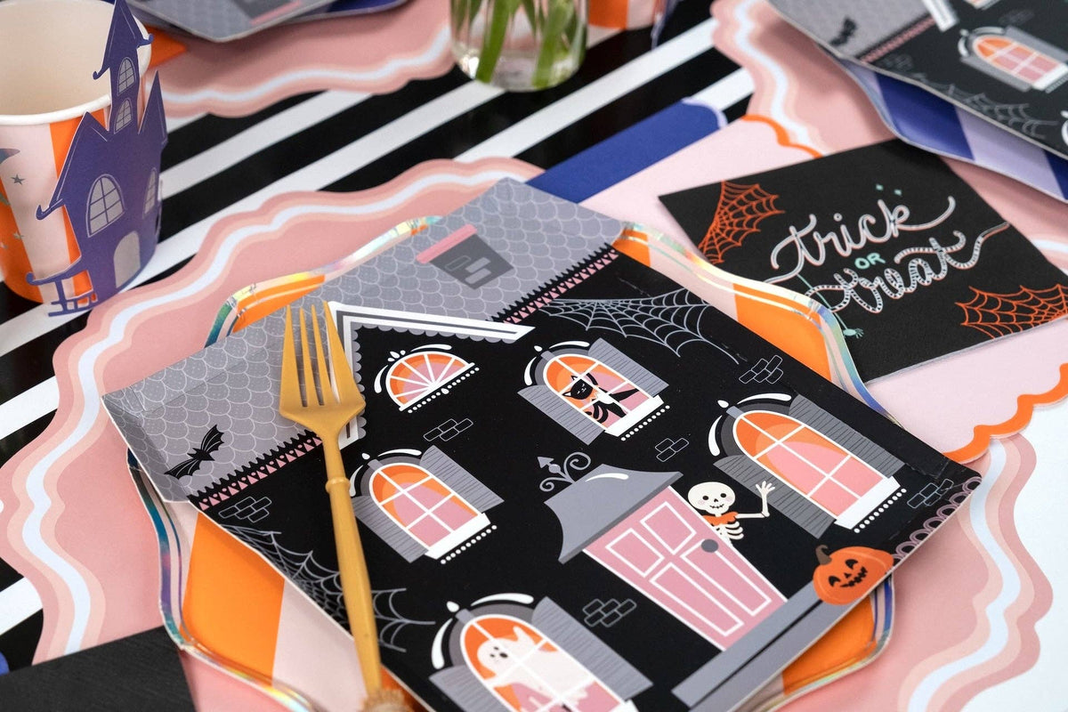 Halloween dessert table with haunted house shaped plates, a trick or treat calligraphy card, and lavender accents