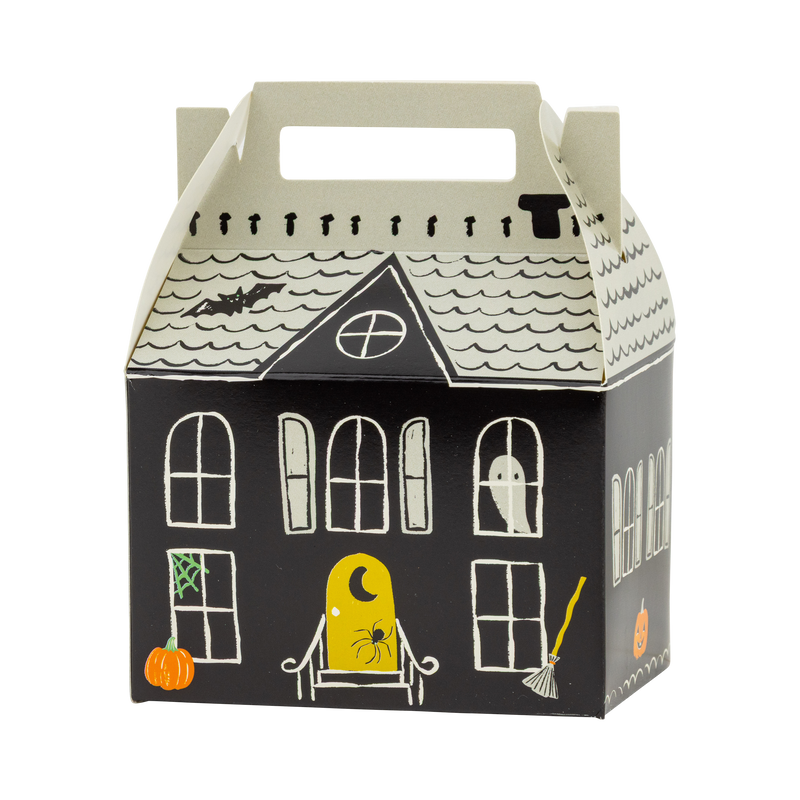 Single assembled haunted house box on a white background, three-quarter angle showing the front facade with arched windows, ghost, yellow door, pumpkin, broom, and green spiderweb, plus the side wall, cream shingled roof, and cut-out carry handle. Clean hero product shot.