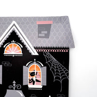 Back view of the haunted house shaped paper plate showing the grey roof and scalloped base on a white background
