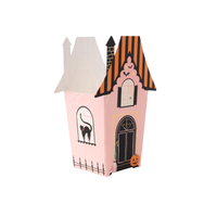 Pink haunted house treat box folded into a gabled manor with gold-foil windows, a black cat, bat, spider, pumpkin, and orange-black striped roof, front view on white background.