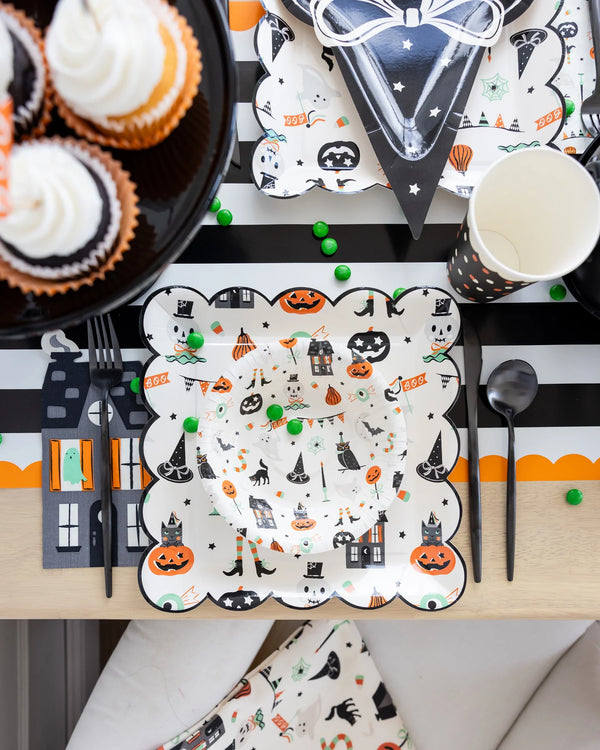 Haunted Mansion napkin styled in a Halloween tablescape with coordinating plates and stripes.