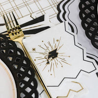 A grad cap napkin tucked beside a black lattice plate for a polished Ivy League Chic event.