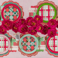 Bold centerpiece with peonies and assorted dotted plates down the table.