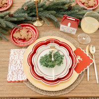 Detailed view of the layered Christmas party plates place setting with the Christmas floral plates, gold cutlery, and cottage treat box.