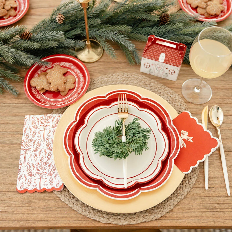 Detailed view of the layered Christmas party plates place setting with the Christmas floral plates, gold cutlery, and cottage treat box.