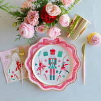 Flat lay of a holiday table featuring the nutcracker plates and coordinating swirled peppermint plates and gold cups.
