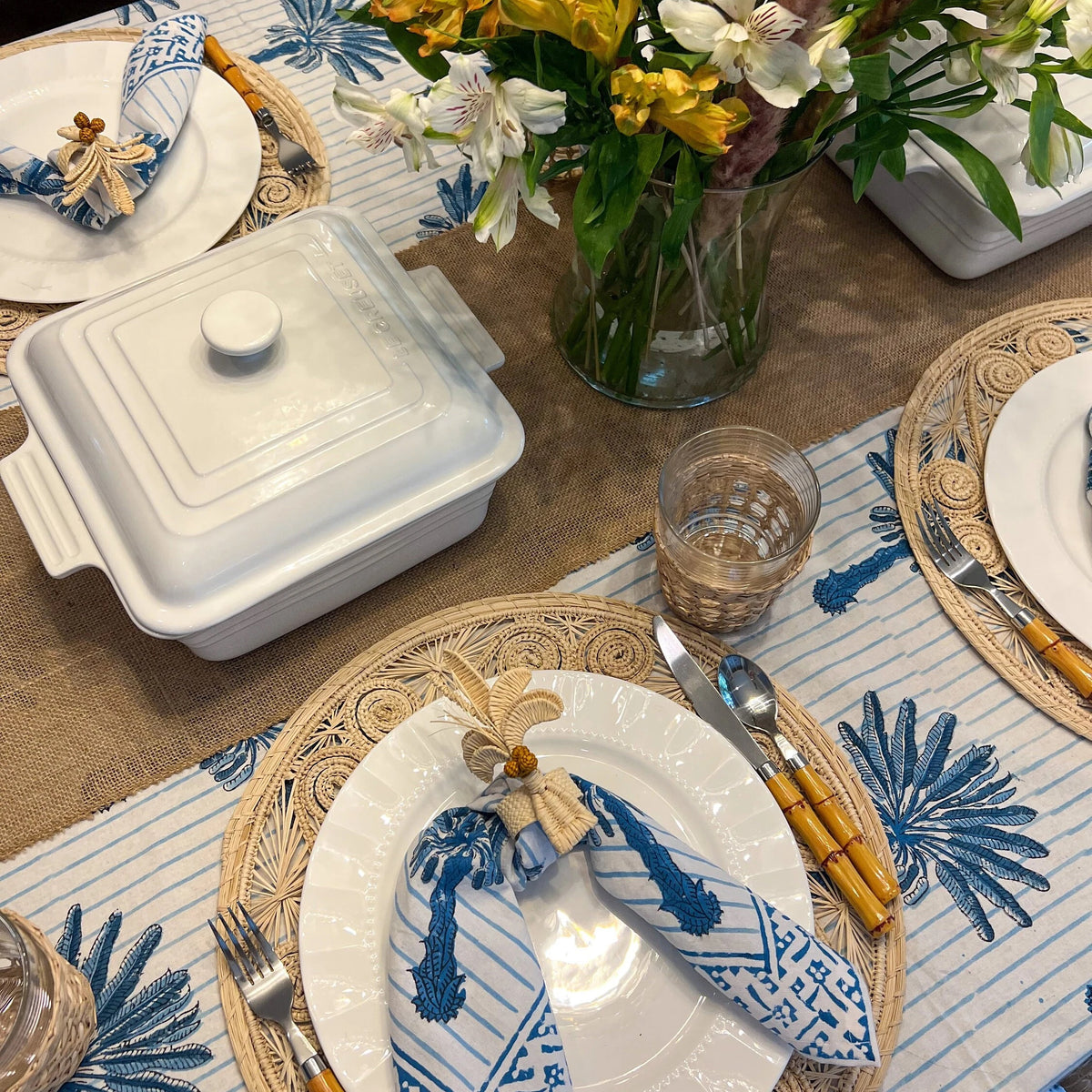 Escape to the tropics at every meal with our woven Palm Tree Napkin Rings. Crafted to complement your tropical table decor, these napkin rings feature natural-colored palm trees with brown coconuts, adding a coastal touch to your table. Perfect for hosting a luau or simply spicing up dinner, these palm tree napkin rings offer an instant vacation vibe.