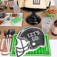 Football party table featuring football helmet shaped paper plates