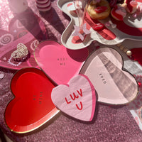 Red and pink paper cocktail napkins shaped like a heart and the words love u; perfect for a anniversary party, bachelorette  or an engagement party