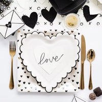 White paper cocktail napkins with small black hearts and scalloped edges - perfect for valentines day, galentines day or an anniversary party