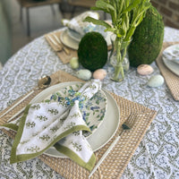 A sage green tablecloth with a floral print perfect for Easter and Spring