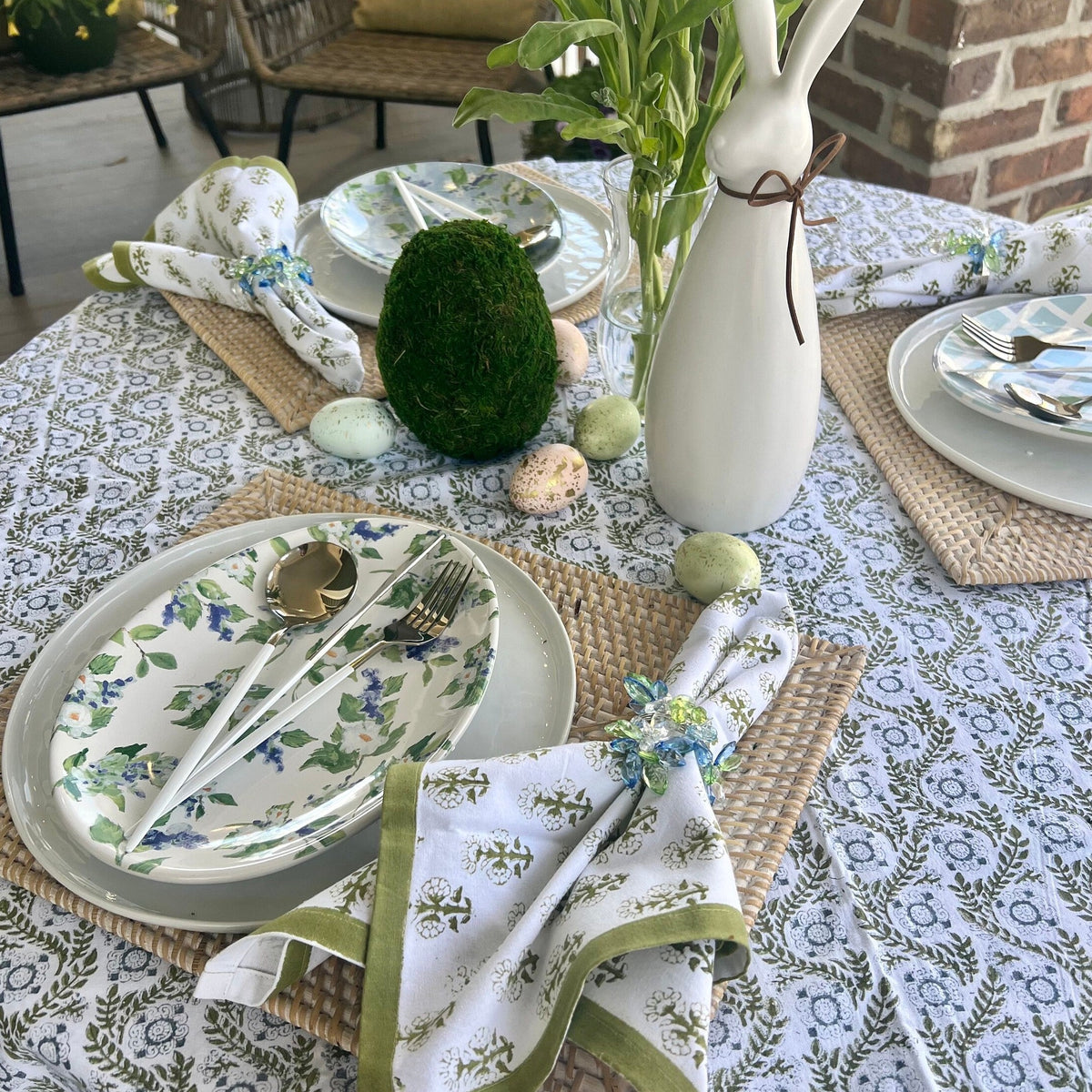 A sage green tablecloth with a floral print perfect for Easter and Spring