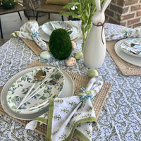 A sage green tablecloth with a floral print perfect for Easter and Spring