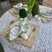 A sage green tablecloth with a floral print perfect for Easter and Spring