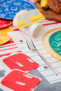 Backpack napkin beside blue plate on notebook placemat.