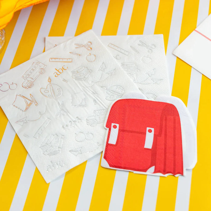 School‑themed table with backpack napkins overhead view.