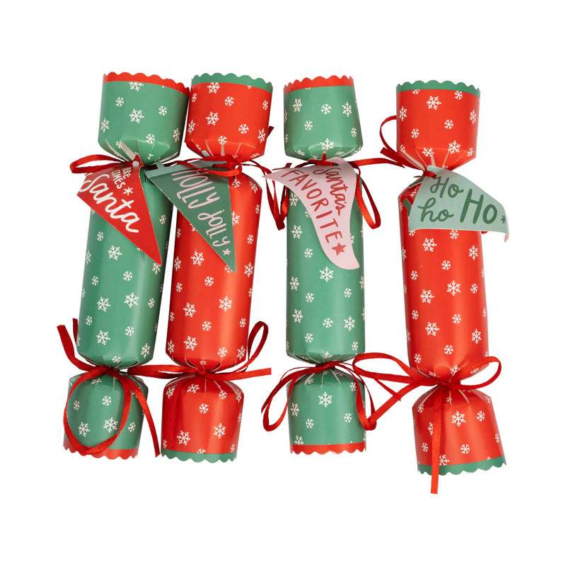 Isolated set of four assembled Christmas crackers showing the alternating red and green snowflakes design and paper tags.