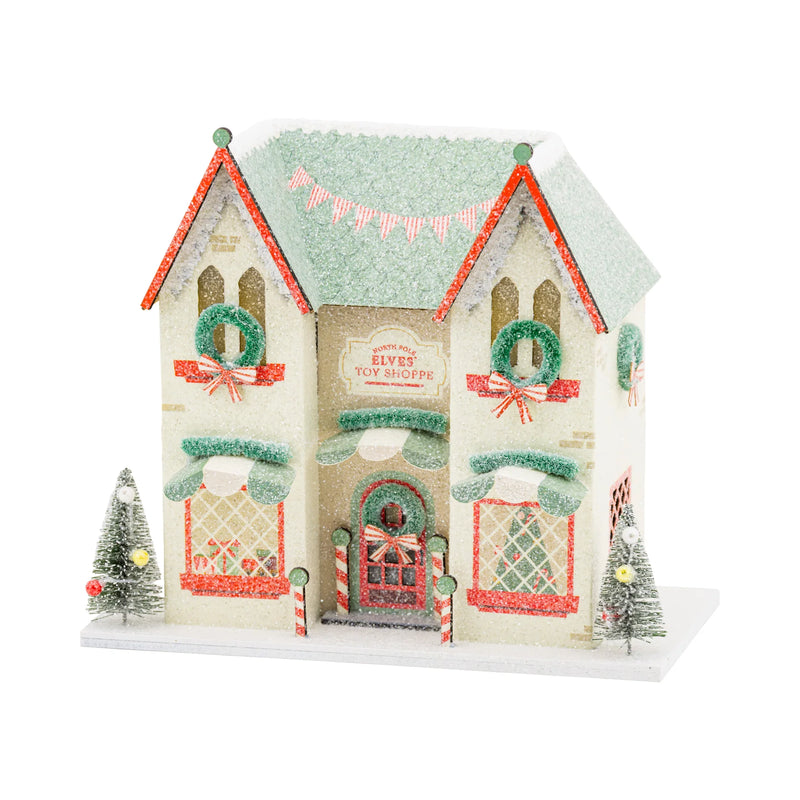 Isolated view of the Elves' Toy Shoppe Christmas putz house featuring a green glitter roof and detailed storefront.
