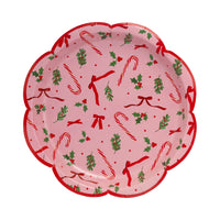 Isolated view of a single pink Christmas plate showing the candy cane and holly repeat pattern.