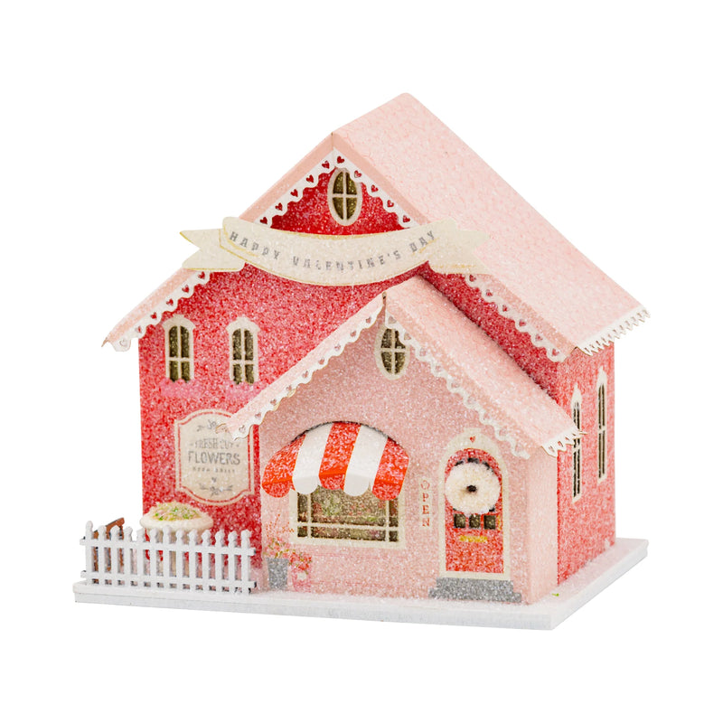 Isolated view of the flower shop putz house with pink and red glitter and a "Happy Valentine's Day" banner.