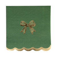 Close-up of a single dark green napkin featuring a gold foil accents bow and a scalloped edge.