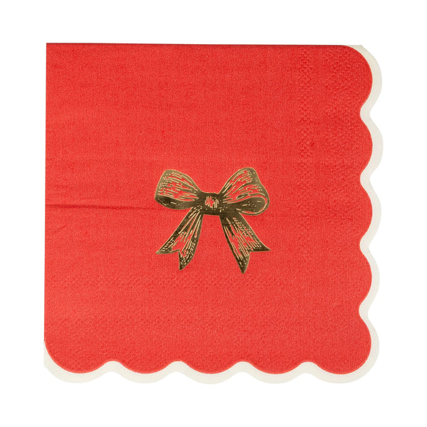 Close-up of a single red Christmas napkin featuring a gold foil accents bow design.