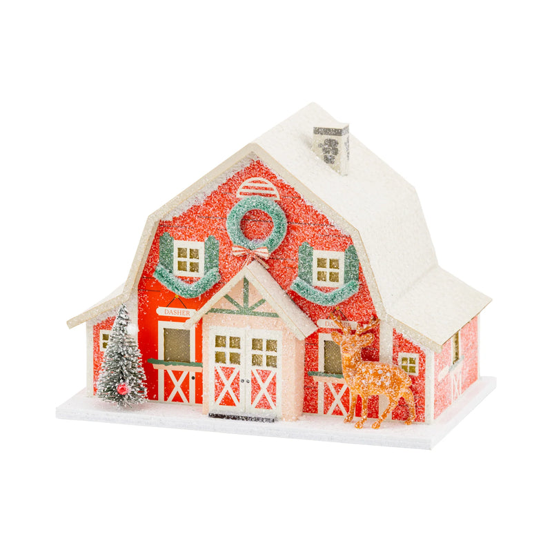 Isolated view of the red glitter Reindeer Barn decor Christmas putz house with a deer figurine and snow-dusted roof.
