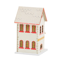 Isolated view of the side of a red glitter putz house with white windows and chimney.