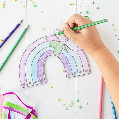 Child coloring a rainbow craft during a St. Patrick’s Day activity