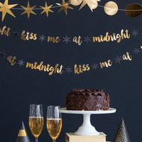 Gold Kiss Me at Midnight letter banner hung against a wall