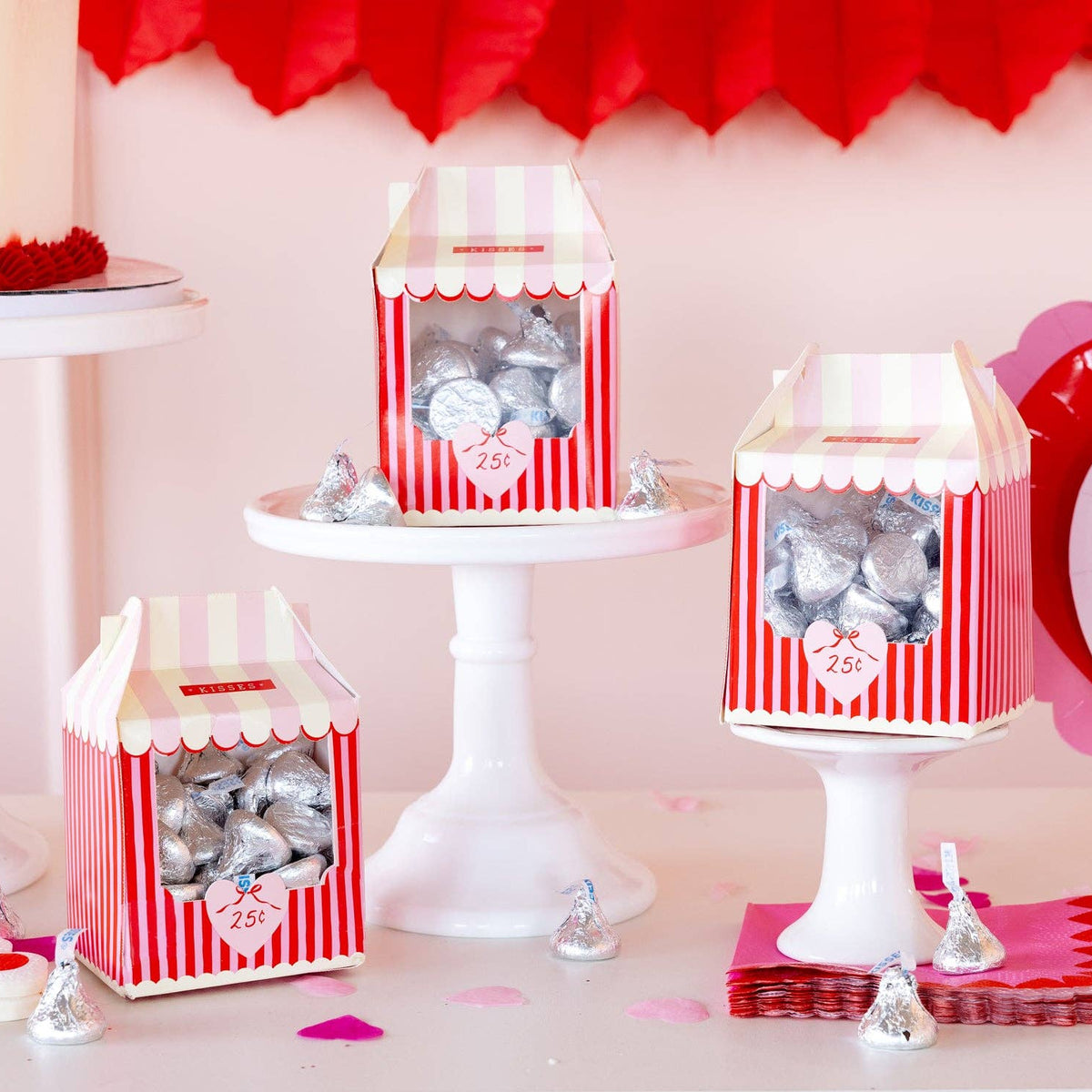 Kissing booth treat boxes displayed on dessert stands with candy