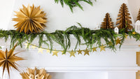 Kraft paper Christmas tree styled on a mantel with a star garland and greenery
