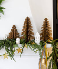 Large kraft paper Christmas trees styled on a mantel with greenery