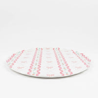 Side profile of a flat large paper plate with pink ribbon pattern