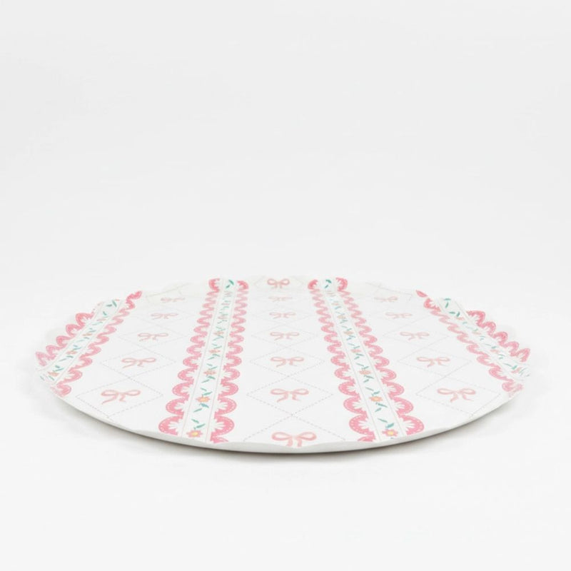 Side profile of a flat large paper plate with pink ribbon pattern