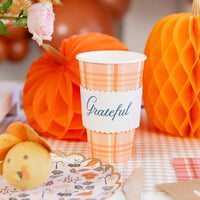 Plaid cup with “Grateful” wrap on a dessert table with orange honeycomb pumpkins.