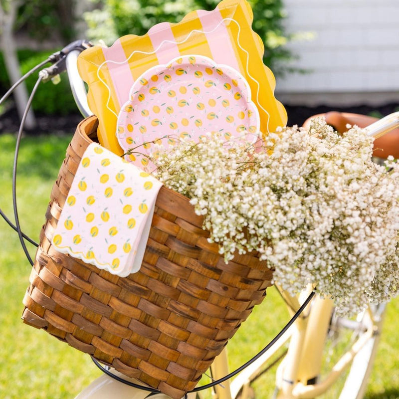 Lemon themed party setup with napkins in basket on bicycle