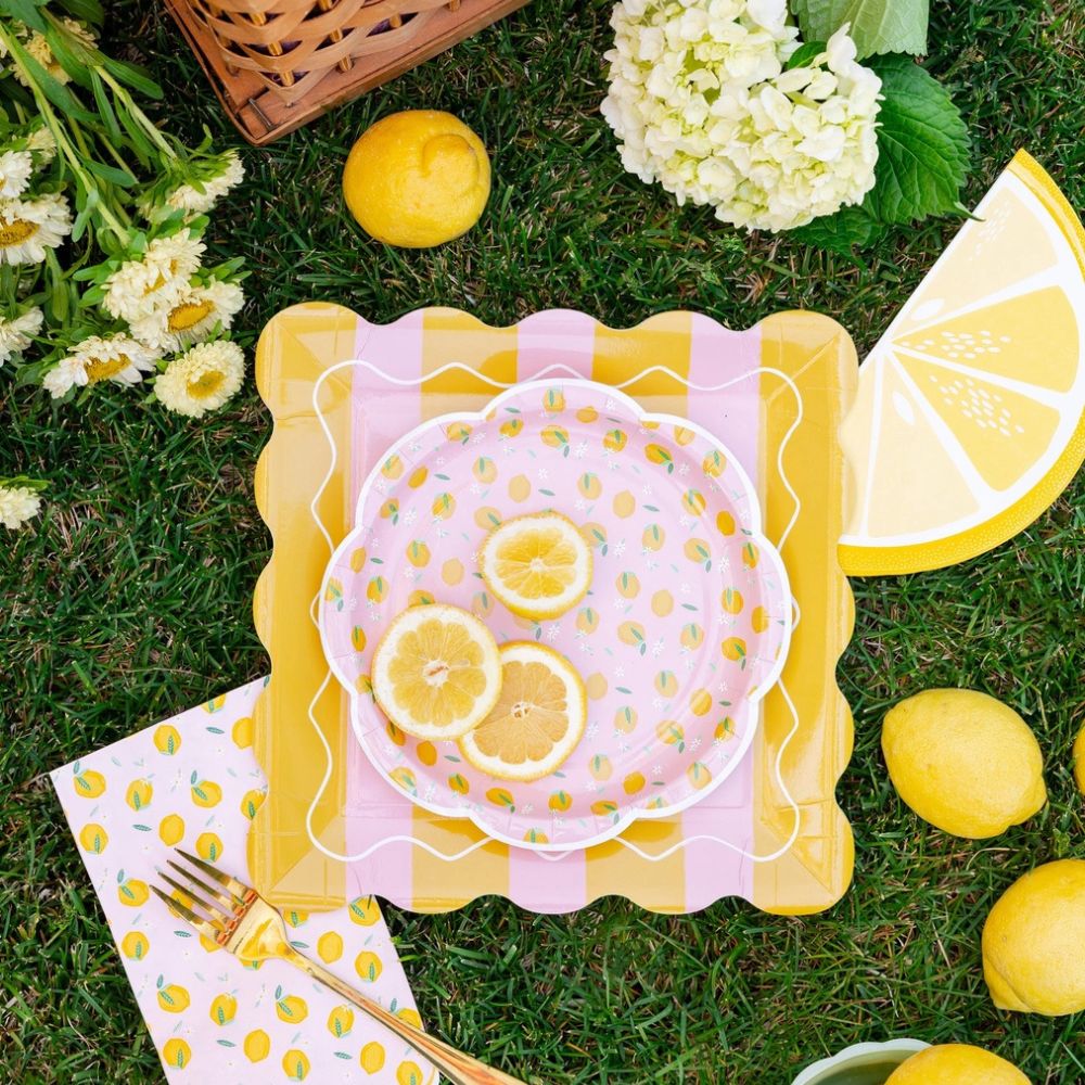 Lemon party setup with plates, lemons, and slice napkin on grass