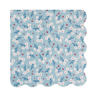 Single light blue blossom floral paper cocktail napkin flat lay showing white flowers with red stars and scalloped edge