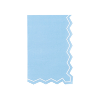 Full straight-on shot of a single light blue zigzag-edge paper guest towel centered on a white background. Portrait orientation. Right edge and bottom edge show the die-cut zigzag silhouette with white inset border line. Left edge and top are straight. Solid light blue field with slight matte paper texture.