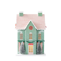 Mint paper house with windows and door glowing from the interior light on a white background