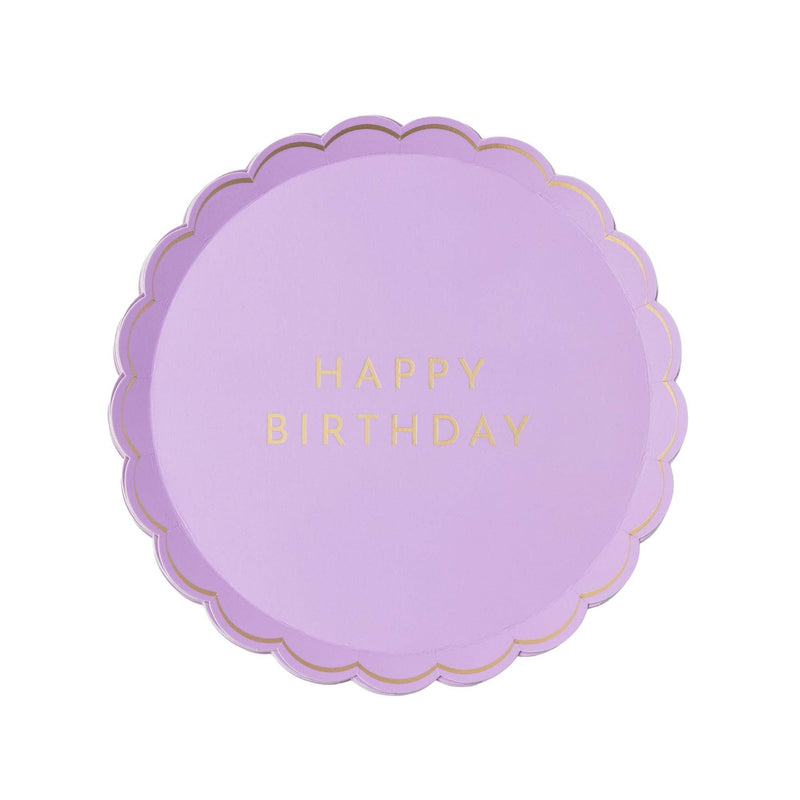 Flat-lay lilac Happy Birthday party plate with a scalloped gold-rimmed edge and gold-foil "Happy Birthday" lettering in the center.
