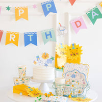 Lion shaped napkins arranged with animal party tableware and birthday decorations.