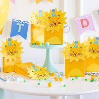 Set of lion themed treat bags arranged on birthday party table with candy decorations
