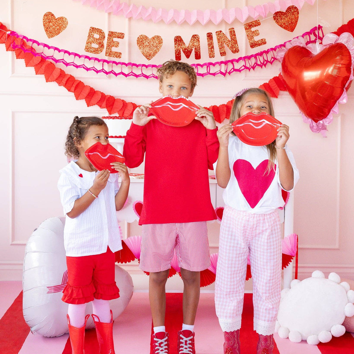 Children holding lips shaped paper plates at Valentine party