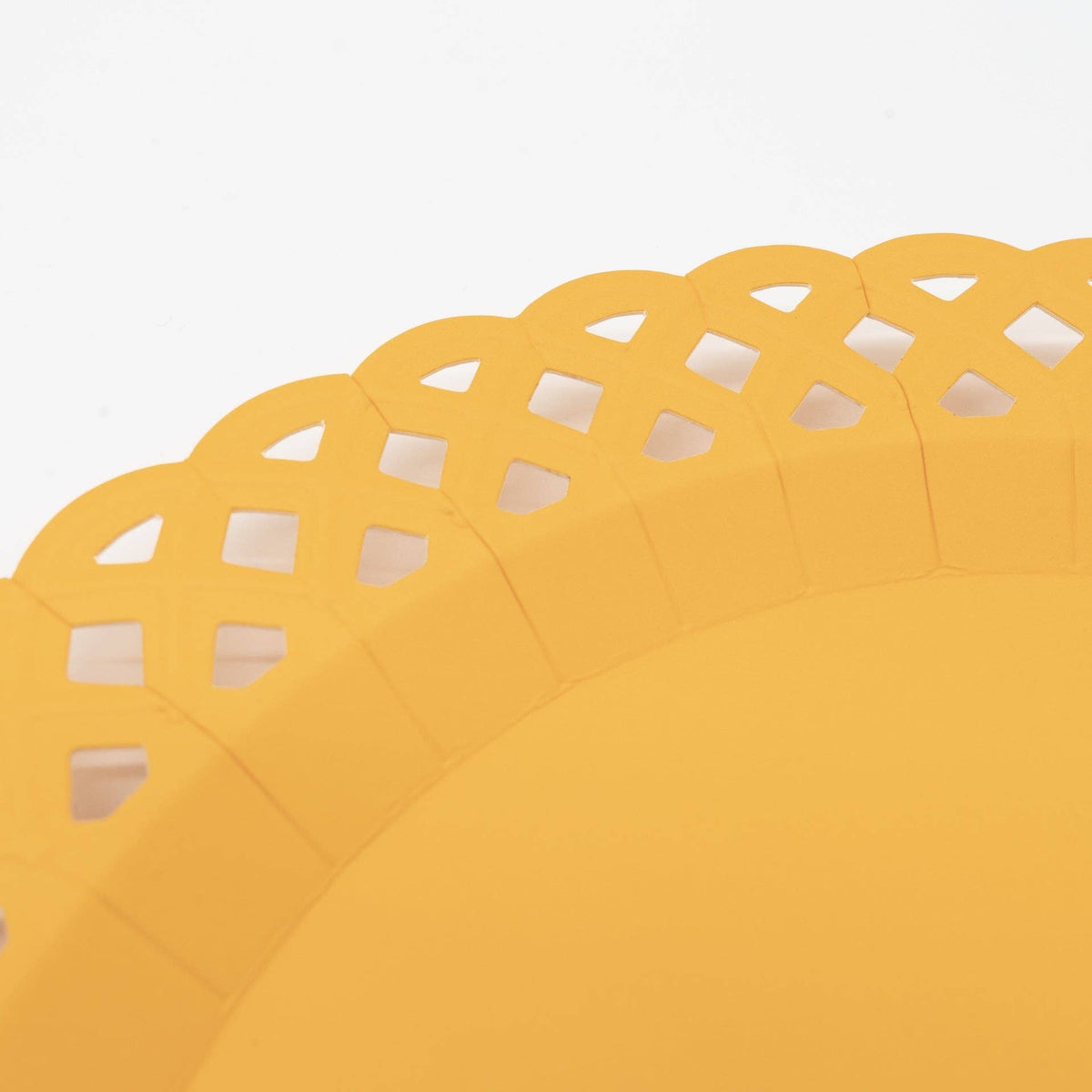 Extreme close-up of a marigold yellow basketweave paper plate showing the raised rim and the intricate woven lattice cutout border in bright golden yellow.