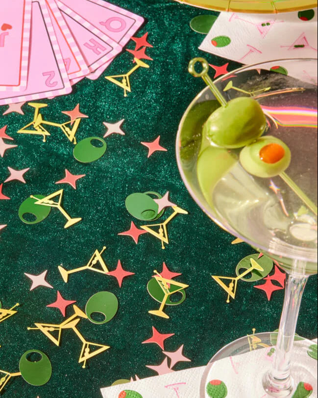 Martini confetti styled on green velvet casino tablescape with real martini glass, playing cards, and paper cocktail napkins