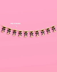 Full pre-strung martini glass banner shown against pink background with "pre-strung" callout